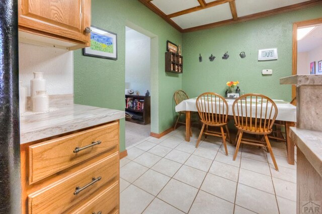 dining area featuring light tile patterned floors, baseboards, and a textured wall