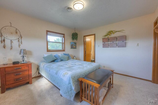 bedroom with light carpet, baseboards, and a textured ceiling