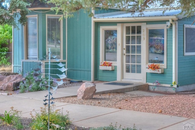 exterior space featuring metal roof and fence