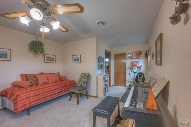 living room with carpet flooring, ceiling fan, and visible vents