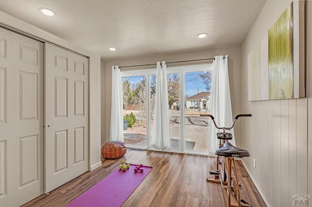 workout room featuring recessed lighting, a textured ceiling, and wood finished floors