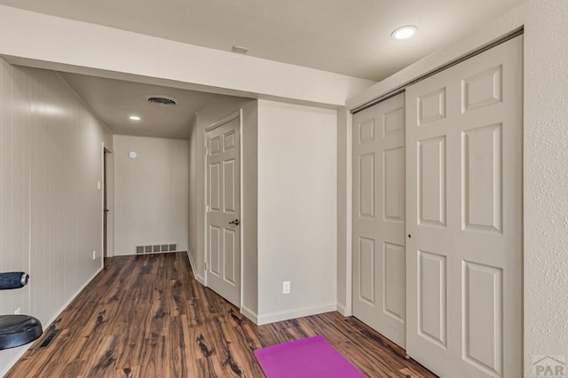 interior space with wood finished floors, visible vents, and baseboards