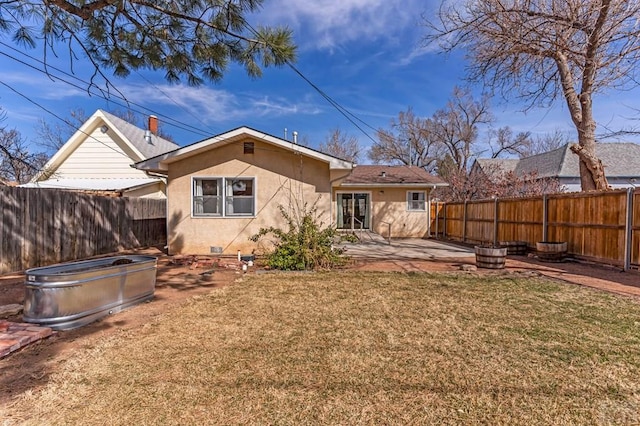 rear view of house with a patio, a fenced backyard, and stucco siding