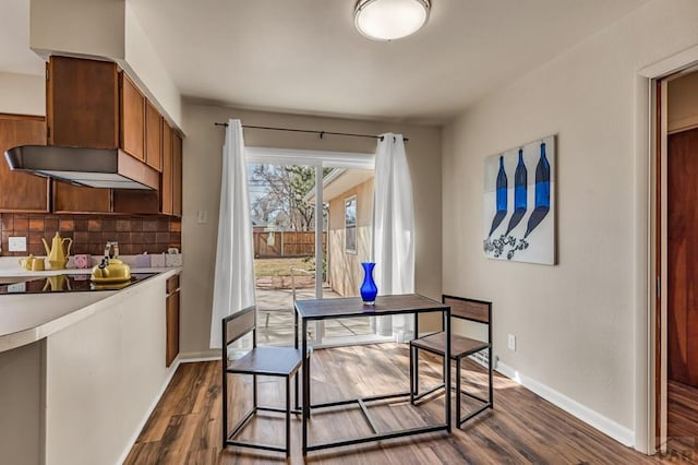 dining space with dark wood finished floors and baseboards