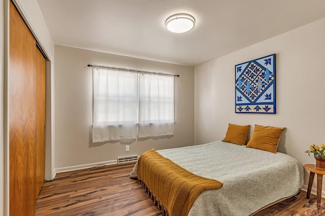 bedroom featuring visible vents, wood finished floors, a closet, and baseboards