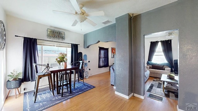 dining room with wood finished floors, visible vents, and a healthy amount of sunlight