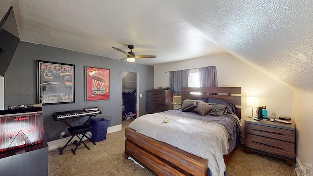 bedroom featuring ceiling fan, a spacious closet, carpet flooring, and a textured ceiling