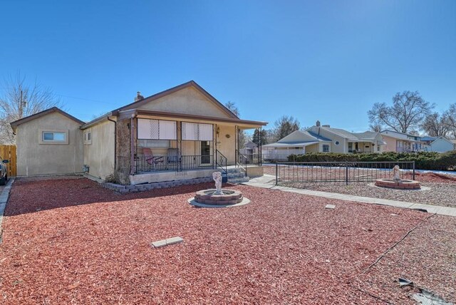 view of front of home with fence and a porch