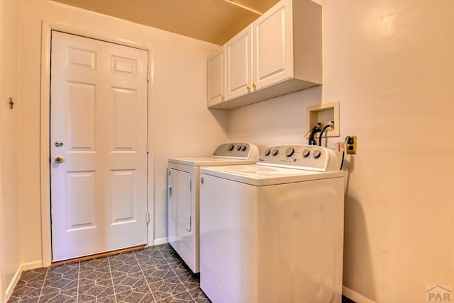 laundry room featuring separate washer and dryer, cabinet space, and baseboards