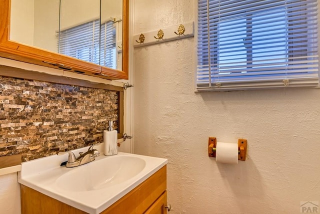 bathroom with a textured wall and vanity