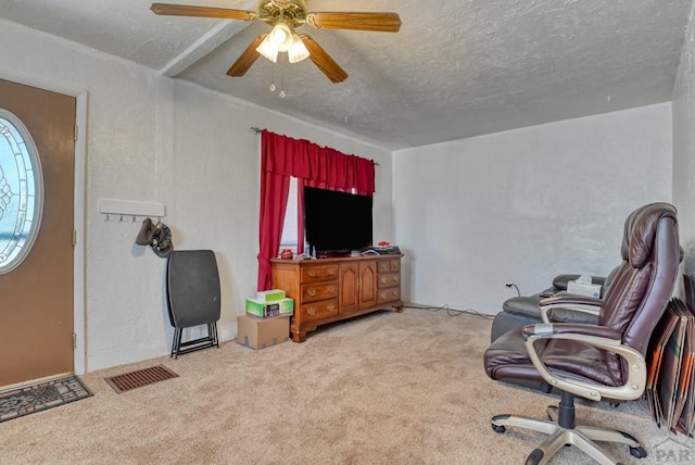 interior space featuring a textured ceiling, visible vents, light carpet, and a ceiling fan