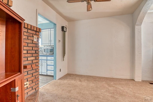 empty room featuring ceiling fan and light colored carpet