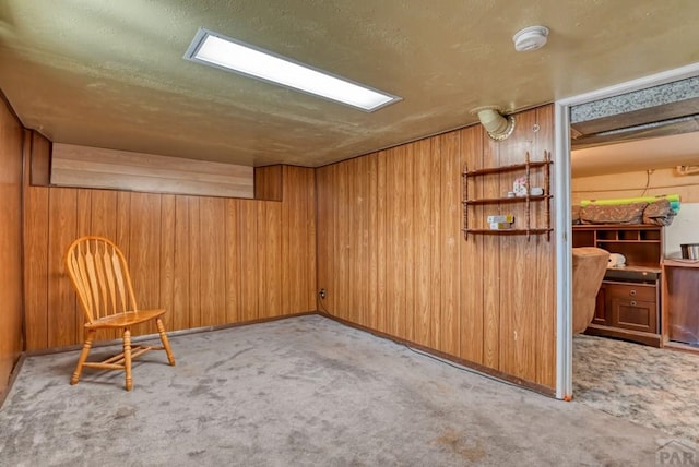 living area with wood walls and light colored carpet