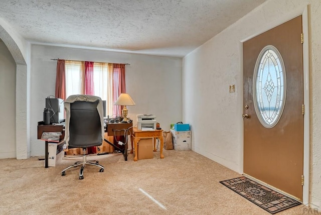 office featuring a textured ceiling, a textured wall, arched walkways, and carpet flooring