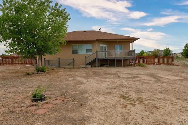 1121 N Calico Rock Ln, Pueblo West, CO 81007 - rear view of house featuring a wooden deck, stairway, and stucco siding