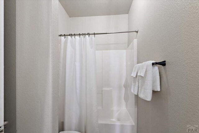 1121 N Calico Rock Ln, Pueblo West, CO 81007 - bathroom featuring a textured wall and curtained shower