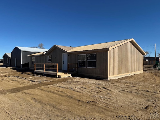 view of front of home with crawl space, metal roof, and a wooden deck