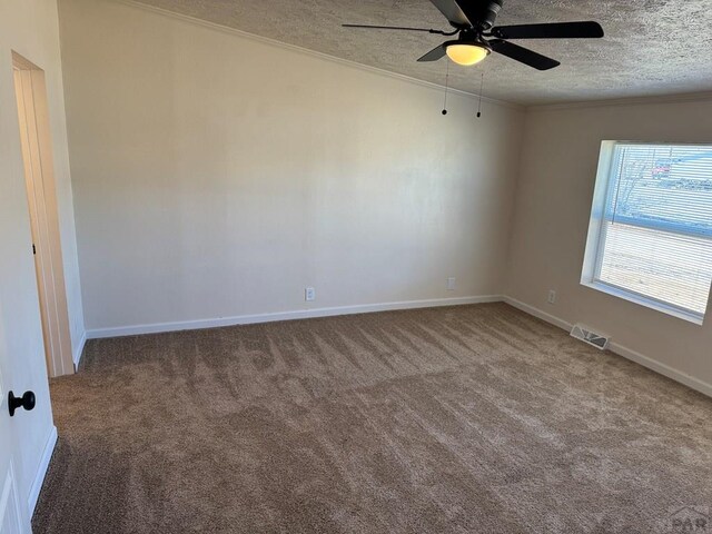 unfurnished room featuring visible vents, ceiling fan, ornamental molding, carpet, and a textured ceiling