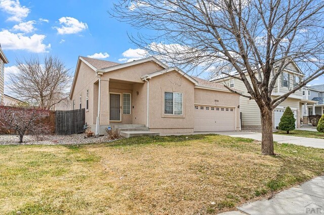 view of front facade featuring concrete driveway, an attached garage, fence, and stucco siding