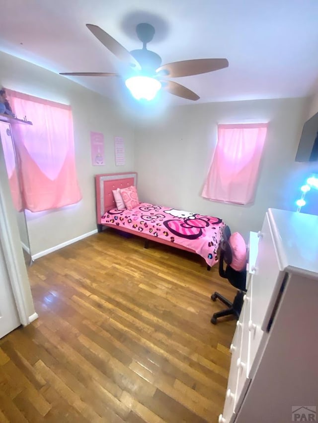 bedroom with ceiling fan, baseboards, and wood finished floors