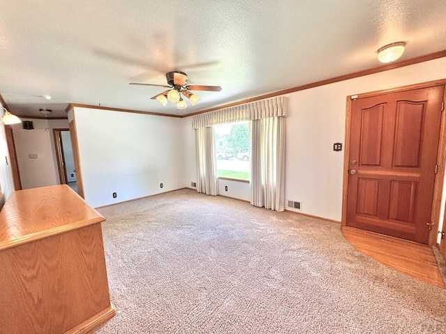 1645 Cherrywood Ln, Pueblo, CO 81005 - unfurnished living room with ceiling fan, light carpet, a textured ceiling, and crown molding