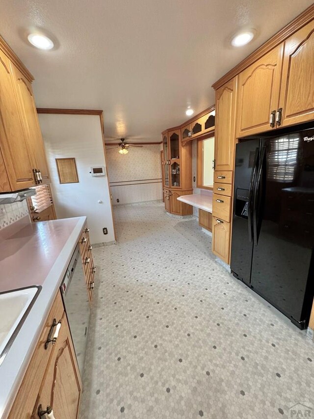 1645 Cherrywood Ln, Pueblo, CO 81005 - kitchen featuring black fridge, a ceiling fan, stainless steel dishwasher, light floors, and a wainscoted wall