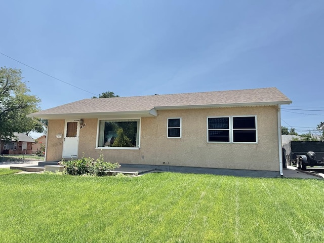 1645 Cherrywood Ln, Pueblo, CO 81005 - back of house featuring a yard, stucco siding, and roof with shingles