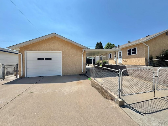 1645 Cherrywood Ln, Pueblo, CO 81005 - view of front of home with driveway, stucco siding, a gate, and a detached garage