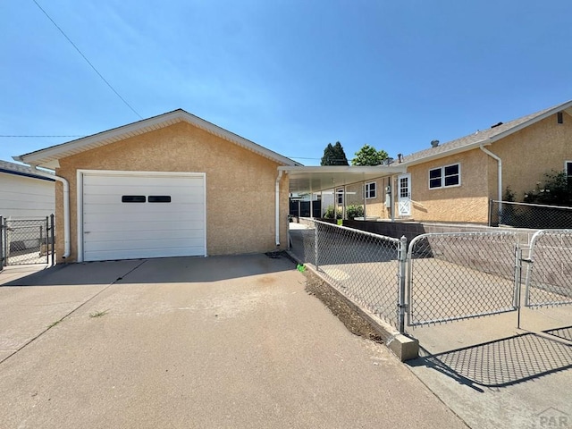 1645 Cherrywood Ln, Pueblo, CO 81005 - view of front facade featuring concrete driveway, stucco siding, a gate, and a detached garage
