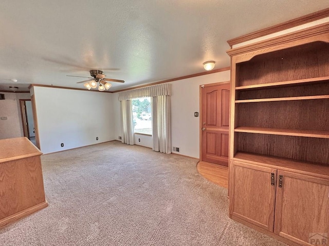 1645 Cherrywood Ln, Pueblo, CO 81005 - unfurnished living room featuring a ceiling fan, light colored carpet, ornamental molding, and a textured ceiling