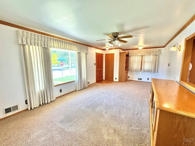 1645 Cherrywood Ln, Pueblo, CO 81005 - unfurnished living room featuring ornamental molding, ceiling fan, light carpet, and a textured ceiling