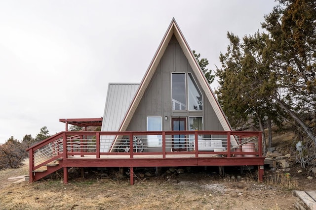 rear view of house featuring board and batten siding and a deck