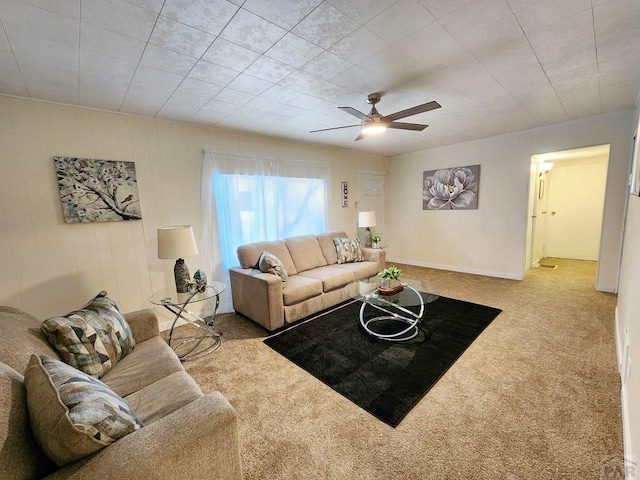 living area featuring a ceiling fan, light carpet, and baseboards