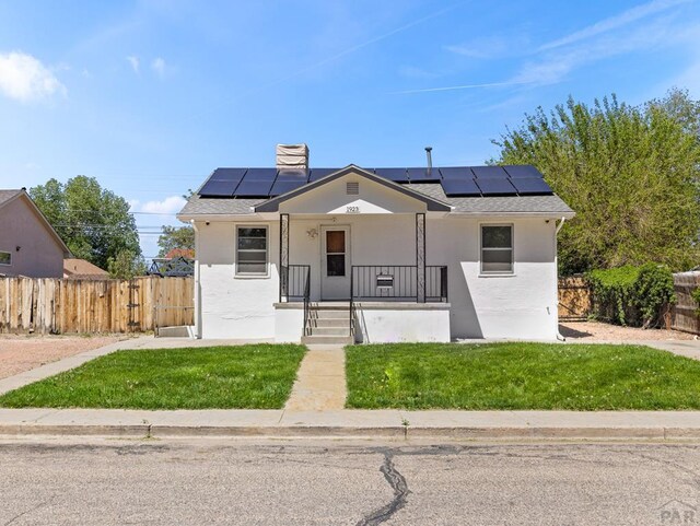 1923 Belmont Ave, Pueblo, CO 81004 - bungalow-style house featuring solar panels, a porch, stucco siding, and roof with shingles
