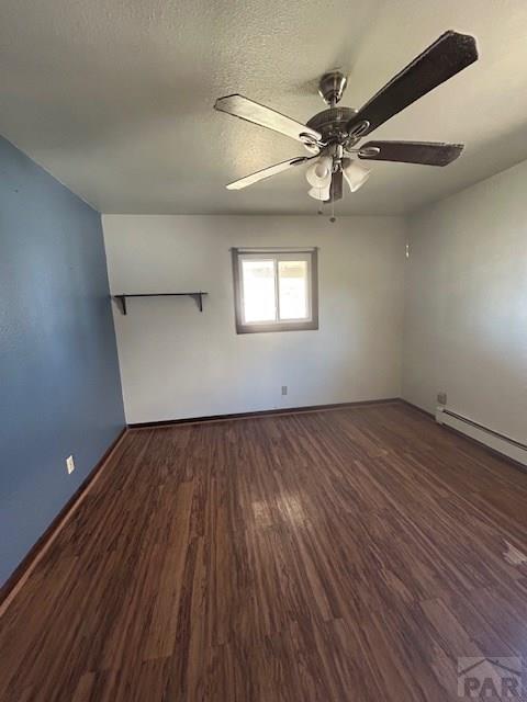 743 Vine Ave, Las Animas, CO 81054 - empty room featuring wood finished floors, a ceiling fan, baseboards, and a baseboard radiator