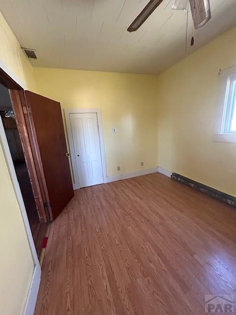 743 Vine Ave, Las Animas, CO 81054 - unfurnished bedroom with wood finished floors, baseboards, and a ceiling fan