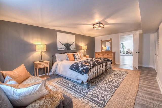 bedroom with baseboards and wood finished floors