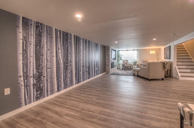 unfurnished living room featuring stairs, wood finished floors, and recessed lighting