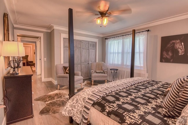 bedroom featuring baseboards, wood finished floors, and crown molding