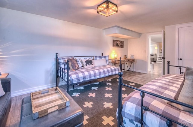 bedroom with baseboards and wood finished floors