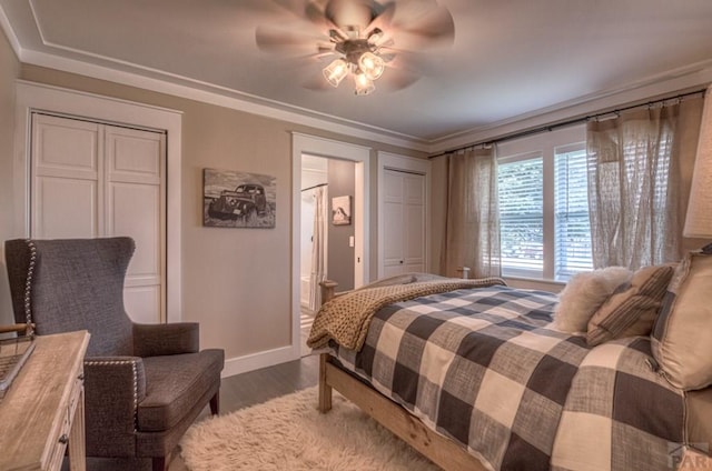 bedroom featuring a ceiling fan, ensuite bathroom, dark wood-style floors, and baseboards