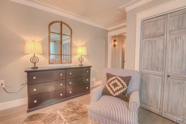 living area with crown molding, baseboards, and wood finished floors