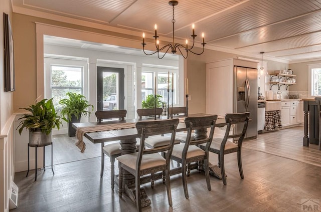 dining space featuring wood finished floors, an inviting chandelier, and wood ceiling
