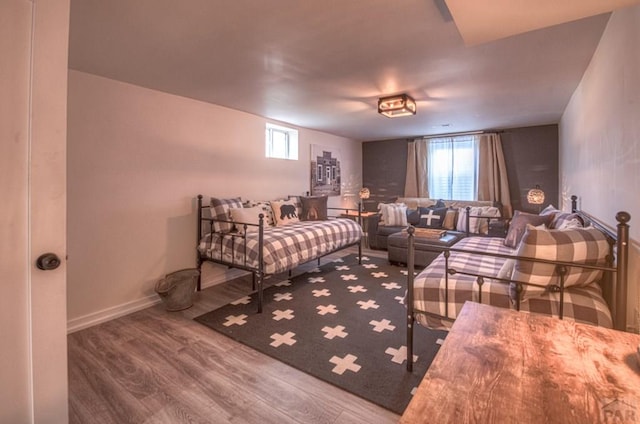 bedroom featuring multiple windows, wood finished floors, and baseboards