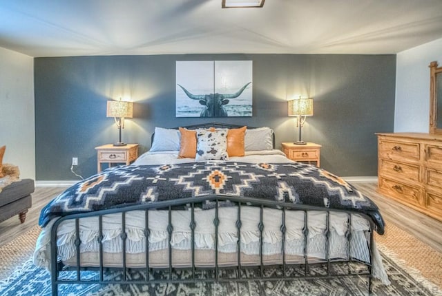 bedroom with baseboards and wood finished floors