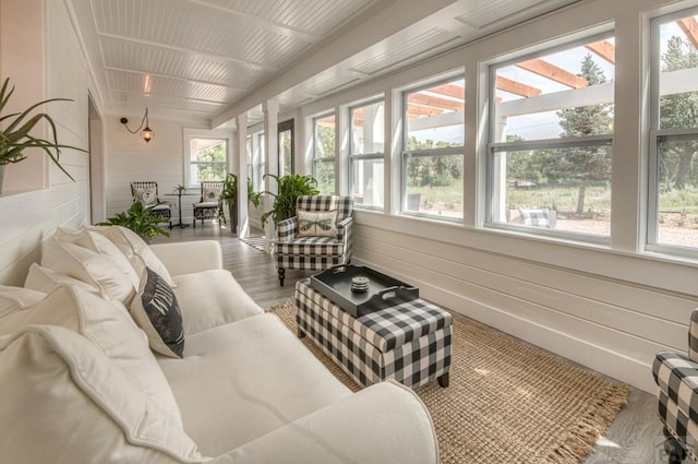 sunroom with wood finished floors and wood walls