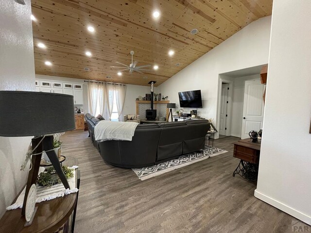 living room featuring wooden ceiling, dark wood-style flooring, a wood stove, high vaulted ceiling, and recessed lighting