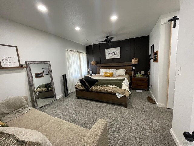 carpeted bedroom featuring a ceiling fan, recessed lighting, baseboards, and a barn door