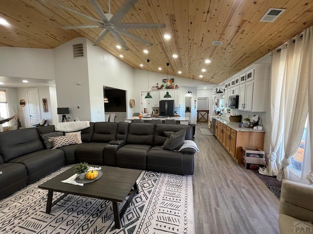 living area featuring high vaulted ceiling, wood ceiling, visible vents, and light wood finished floors