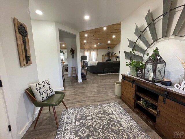 interior space featuring baseboards, vaulted ceiling, wood finished floors, and recessed lighting